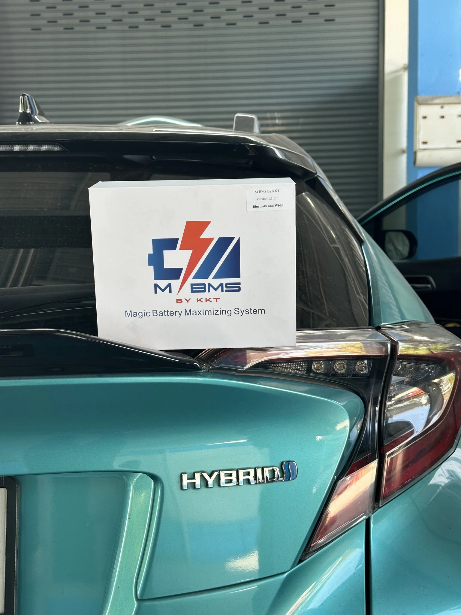 M-BMS package presented beside a hybrid vehicle
